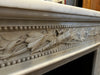 A beaded frieze centred by a delicately carved ribboned, leaf, and berry wreath and sprigs