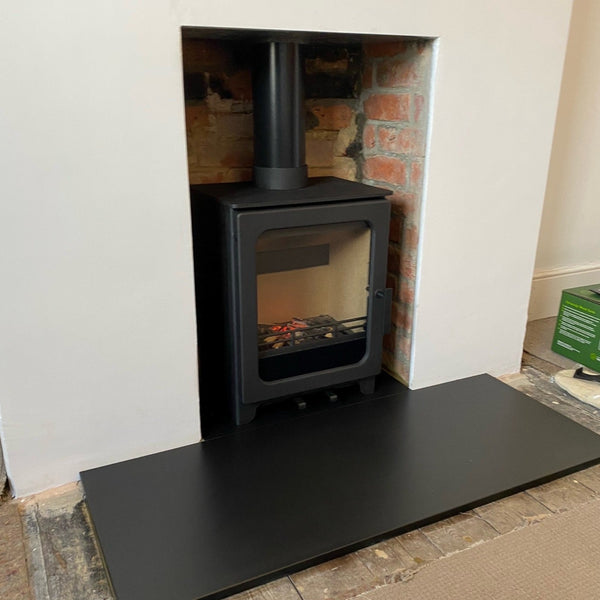 Recently installed ACR Woodpecker WP5 multifuel stove featuring slate hearths and a natural brickwork chamber.