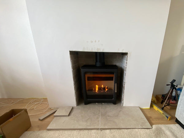 The popular ACR Woodpecker WP5PLUS, ideal for small and compact openings and impressive large glass  door for stunning views of the roaring fires. Fireplace tiles and slate hearths enhance the fireplace. 