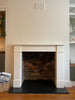 AFTER: The completed fireplace chamber opening with the Hersham Aegean Limestone surround, black slate hearths and cleaned bricks.