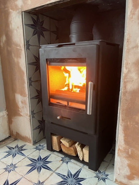 The contemporary Bohemia X30 cube stove installed with customer's fireplace tiles, creating a real focal point.