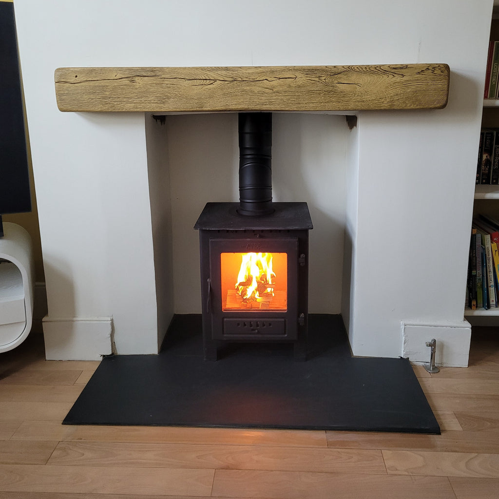 Recently Installed Esse One Wood Burning Ecodesign Stove featuring a 0-90 degree adjustable swivel elbow fitted in a rendered chamber with a beam and slate hearth. 