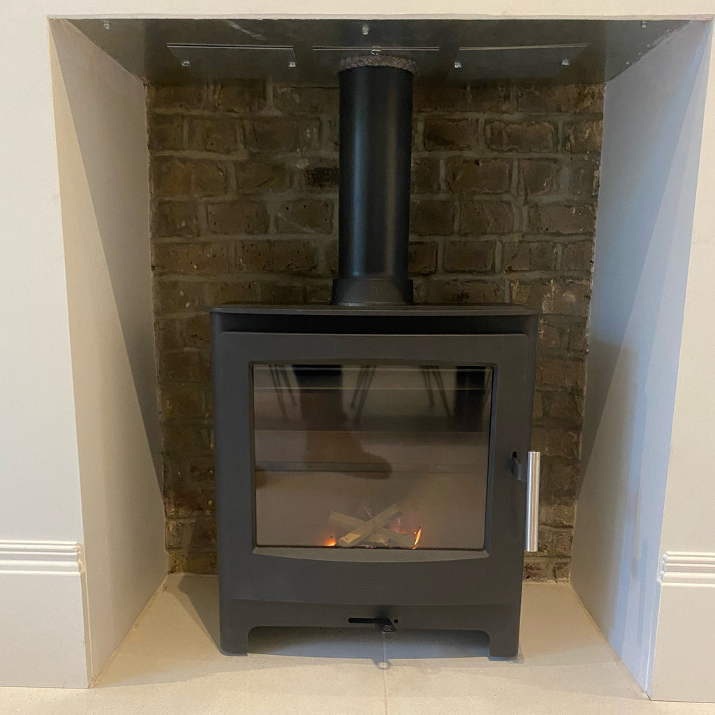Recently installed HETA Ambition 5 wood burning stove ecodesign featuring cleaned brickwork and painted chamber. 