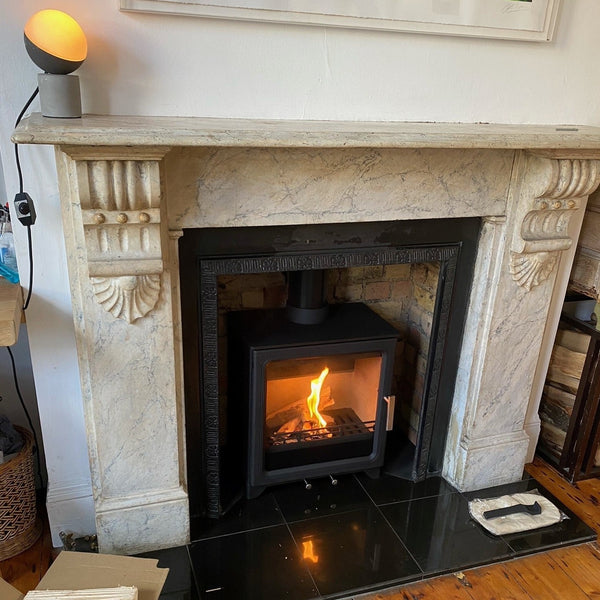 ACR Woodpecker WP5PLUS Eco Wood/Multi Fuel Stove featuring a cleaned brickwork chamber. The original tiled insert frame has been kept within an original marble surround.